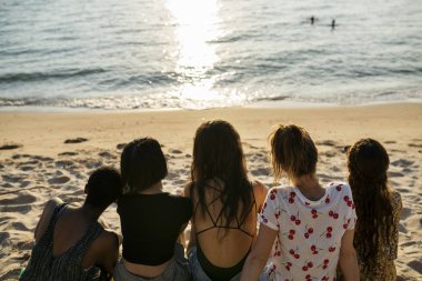 Sahilde oturan kızlar