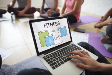 yoga sınıfında dizüstü bilgisayar kullanan kişi