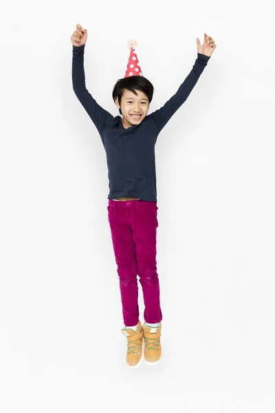 Boy jumping in birthday hat — Stock Photo, Image