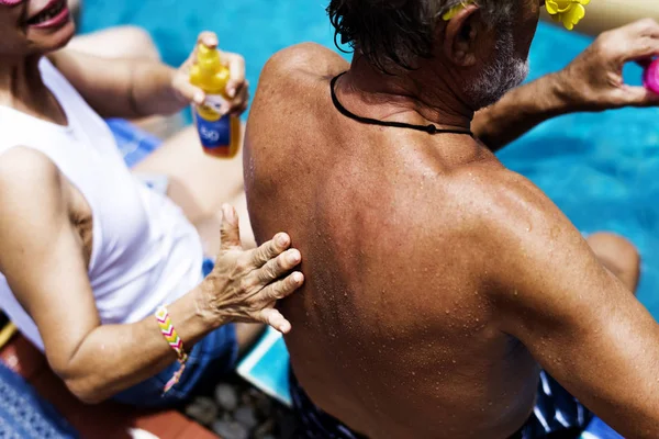 Woman smears man with sunscreen — Stock Photo, Image