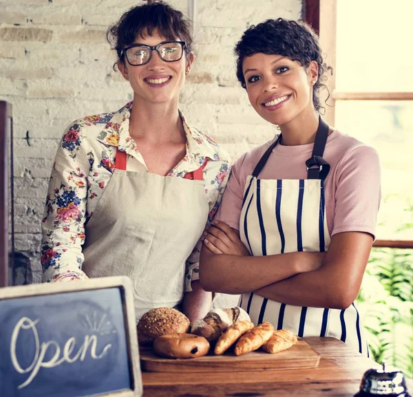 Donne amiche al negozio di panetteria sorridente — Foto Stock