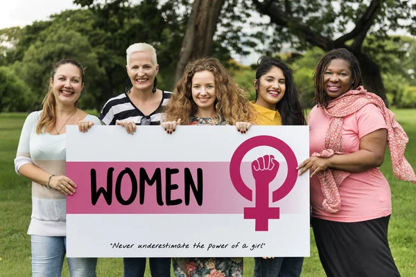 Cinco mujeres sonrientes sosteniendo pancarta — Foto de Stock