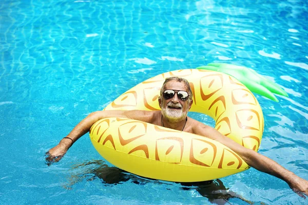 Caucasian man floating in the pool — Stock Photo, Image