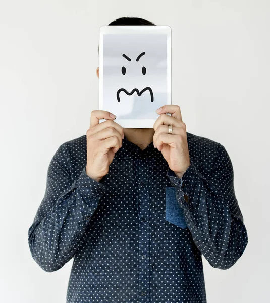 Людина, що закриває обличчя цифровим планшетом — стокове фото