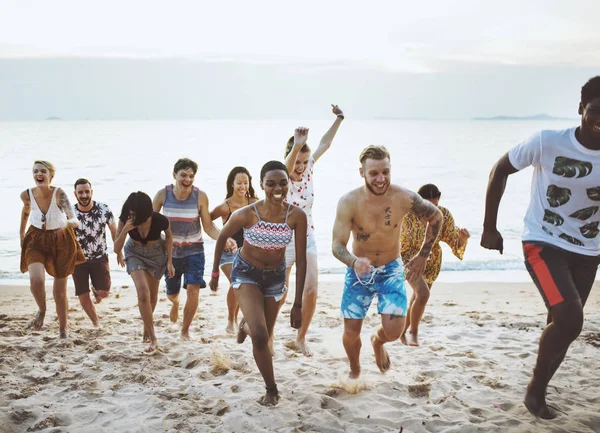 Vrienden uitgevoerd op strand — Stockfoto