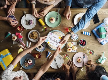 İnsanlar masada doğum günü kutlamak 