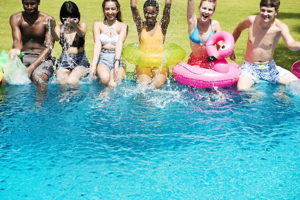 Vrienden zitten bij zwembad — Stockfoto