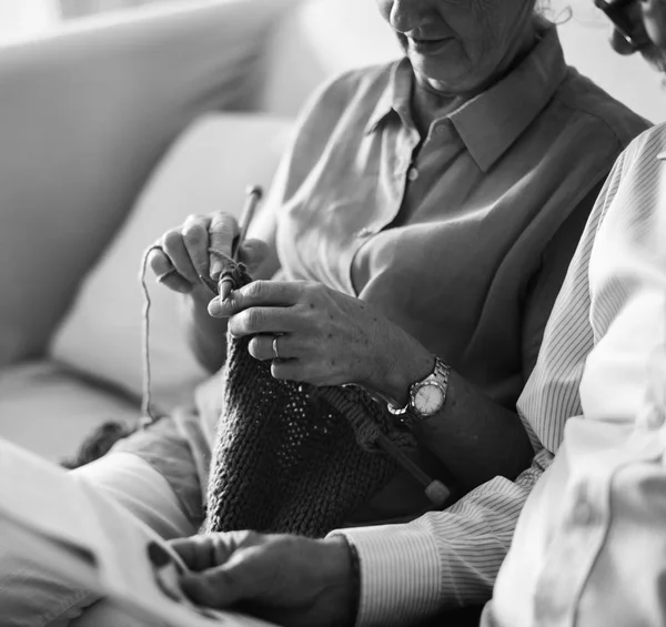Пожилая пара читает газету и вязание — стоковое фото