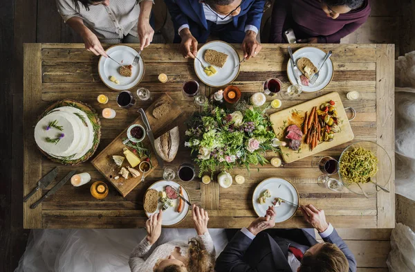 Novia y novio comiendo con amigos — Foto de Stock