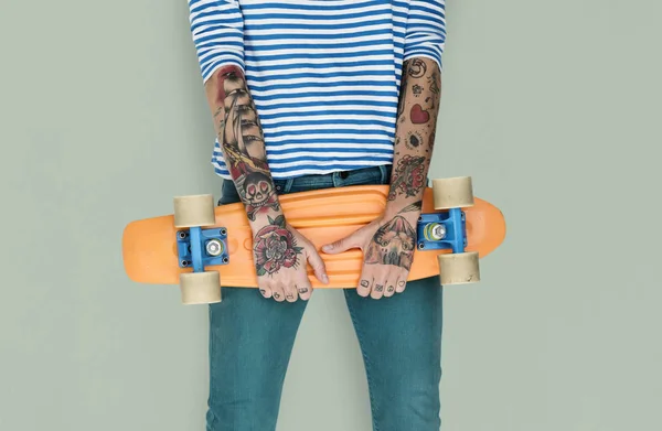 tattooed woman hands holding skateboard