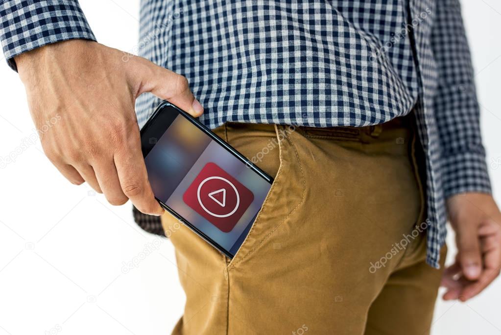 male hand putting smartphone in pocket
