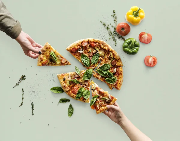 Figyelembe véve a szeletek, pizza keze — Stock Fotó