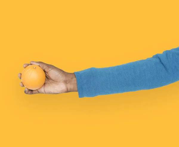 Brazo de mano sosteniendo naranja — Foto de Stock