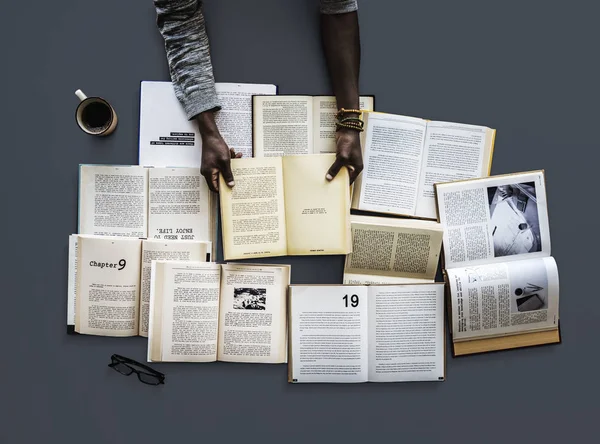 Hände am Tisch mit vielen Büchern — Stockfoto