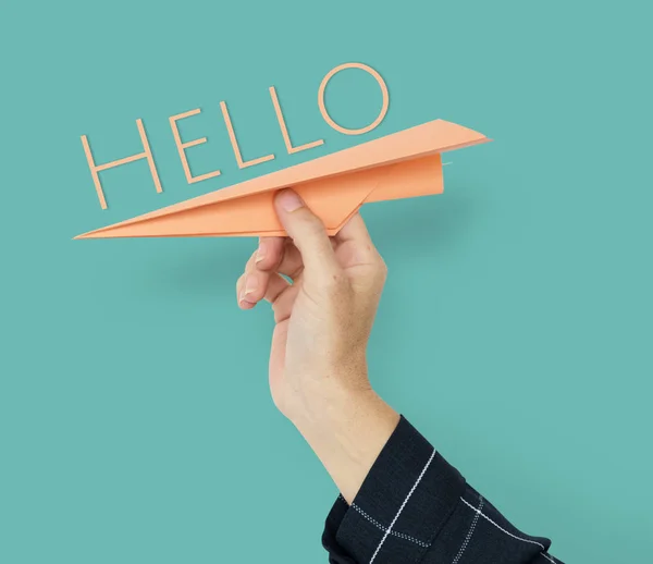 Mão segurando avião de papel laranja — Fotografia de Stock