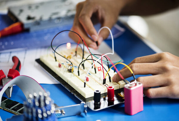 hands working on breadboard