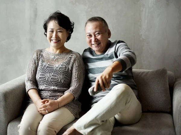 Asian senior couple sitting together at sofa — Stock Photo, Image