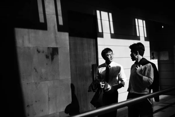 Dois homens de negócios caminhando e conversando juntos — Fotografia de Stock