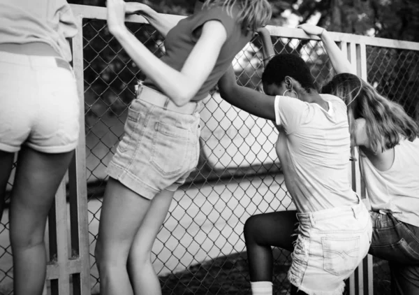Женщины перелезают через забор — стоковое фото