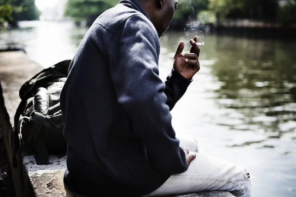 Uomo seduto e fumare — Foto Stock