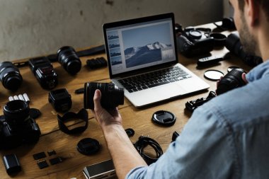 fotoğraf makinesi dizüstü bilgisayarda çalışan adam