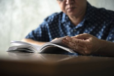 Son sınıf öğrencisi evde kitap okuyor.