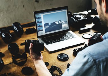 fotoğraf makinesi dizüstü bilgisayarda çalışan adam