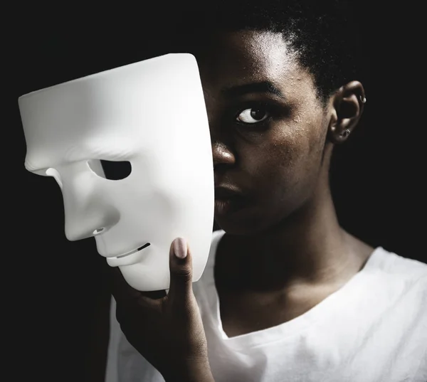 Mulher negra segurando máscara branca — Fotografia de Stock