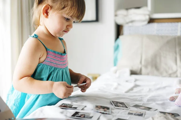 Маленька дівчинка дивиться сімейні фото — стокове фото