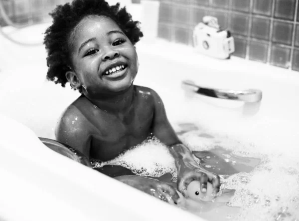 African descent kid enjoying bath tub