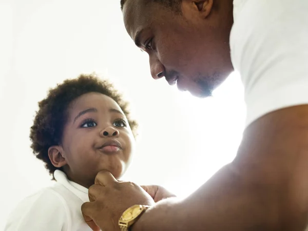 Чёрный отец наряжает своего ребёнка — стоковое фото