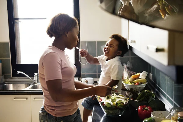 Kid feeding mother with cooking food — Stock Photo, Image