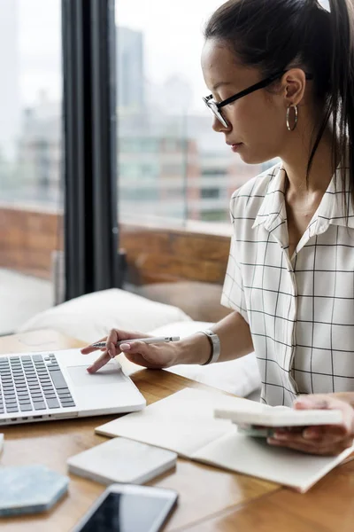 Mulher com óculos trabalhando em um laptop — Fotografia de Stock