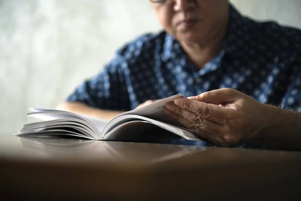 Senior man reading book at home — Stock Photo, Image