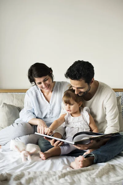Семья читает сказки для дочери — стоковое фото