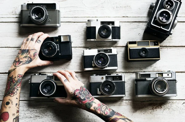 Handen met retro foto camera 's — Stockfoto