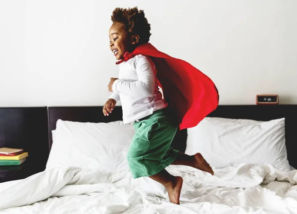 Ребенок прыгает на кровать в халате — стоковое фото
