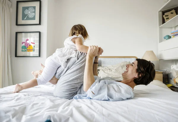 Madre e hija jugando juntas en la cama — Foto de Stock