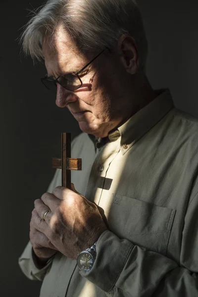 Vieil homme prière avec croix — Photo