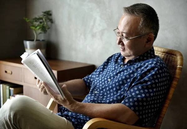 Uomo anziano lettura libro a casa — Foto Stock