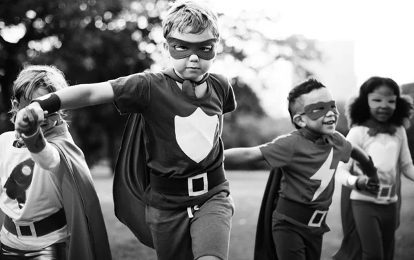 Niños en trajes de superhéroe corriendo — Foto de Stock