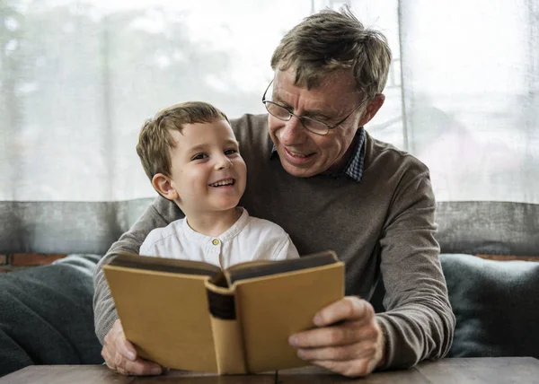 Дедушка и внук читают книгу — стоковое фото