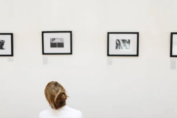 Kembali Melihat Pada Wanita Melihat Frame Dengan Gambar Dalam Pameran — Stok Foto