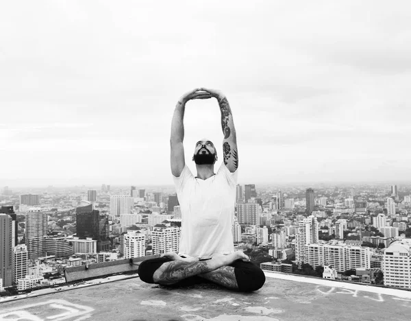 Mann praktiziert Yoga auf dem Dach — Stockfoto