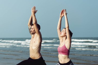 Çift sahilde bir yoga yapıyor