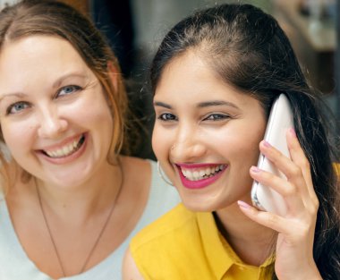 Gülümseyen ve telefonda, özgün konuşurken photoset iki kadın