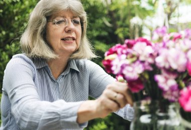 Olgun Bayan çiçek düzenliyor