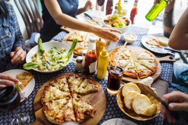 Bir restoranda pizza sahip arkadaşlar