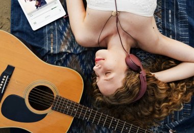 Kadın kumsalda yatıyor.