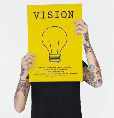 afiş tutarak ve yüz, ampul simgesi afiş kapsayan ellerinde dövmeli kadın 